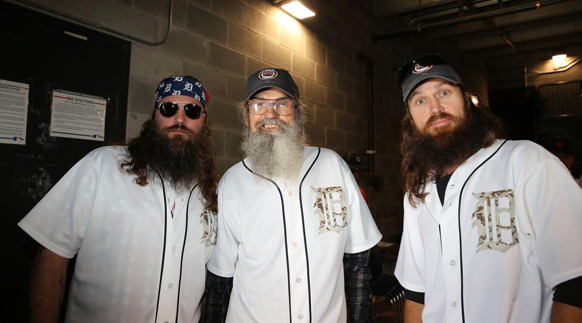 Cast members of "Duck Dynasty," from left, Willie Robertson, Jase Robertson and Phil Robertson, get ready to throw out the first pitch before a Detroit Tigers-Chicago White Sox game in Detroit.