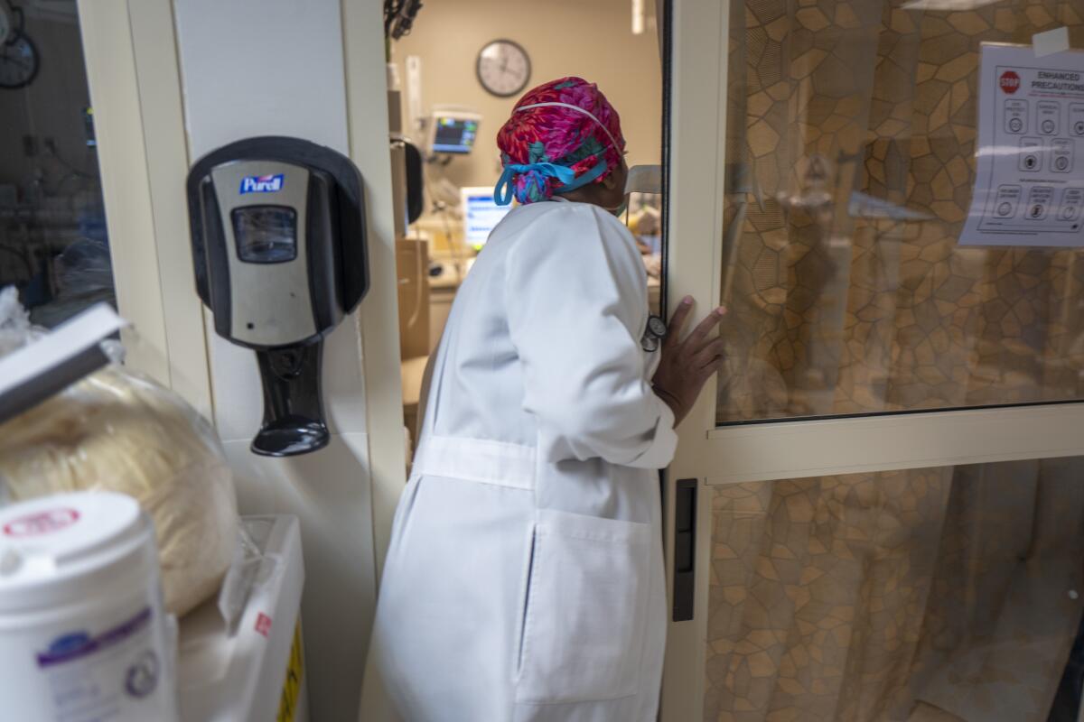 Dr. Anita Sircar looks through a doorway into a room