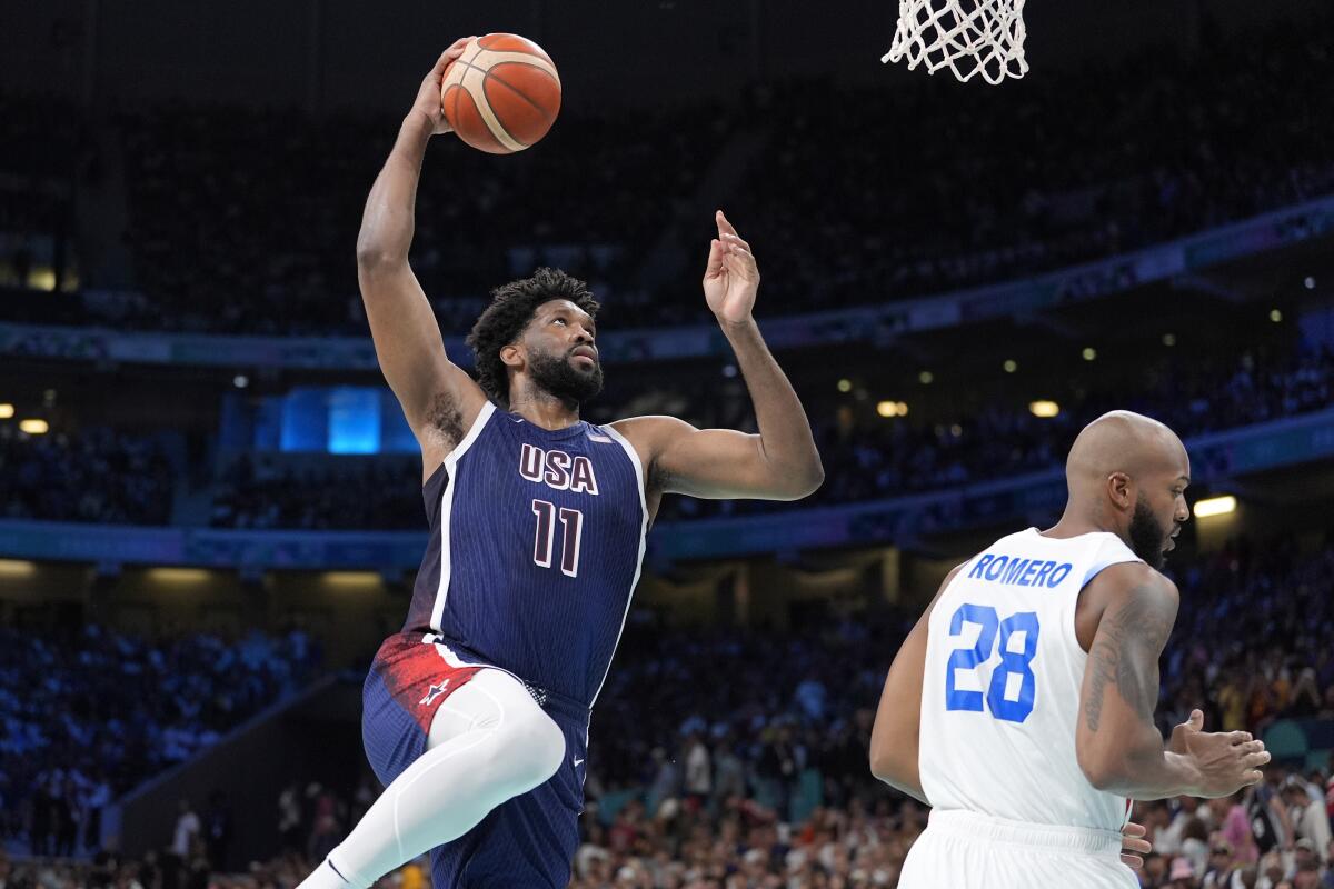 El estadounidense Joel Embiid clava el balón ante el puertorriqueño Ismael Romero 