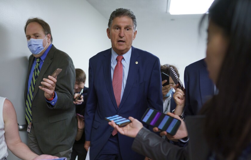 Sen. Joe Manchin is surrounded by reporters