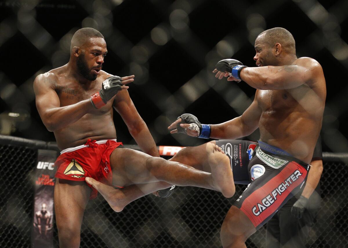 Jon Jones, left, and Daniel Cormier trade kicks in the middle of the octagon at UFC 182 on Jan. 3, 2015.