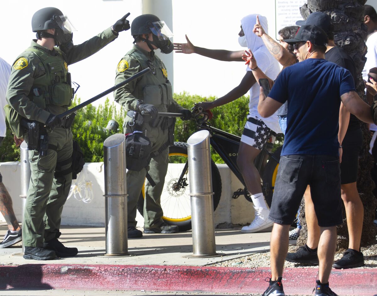 Law enforcement and protesters clash at a protest in Huntington Beach in May 2020.