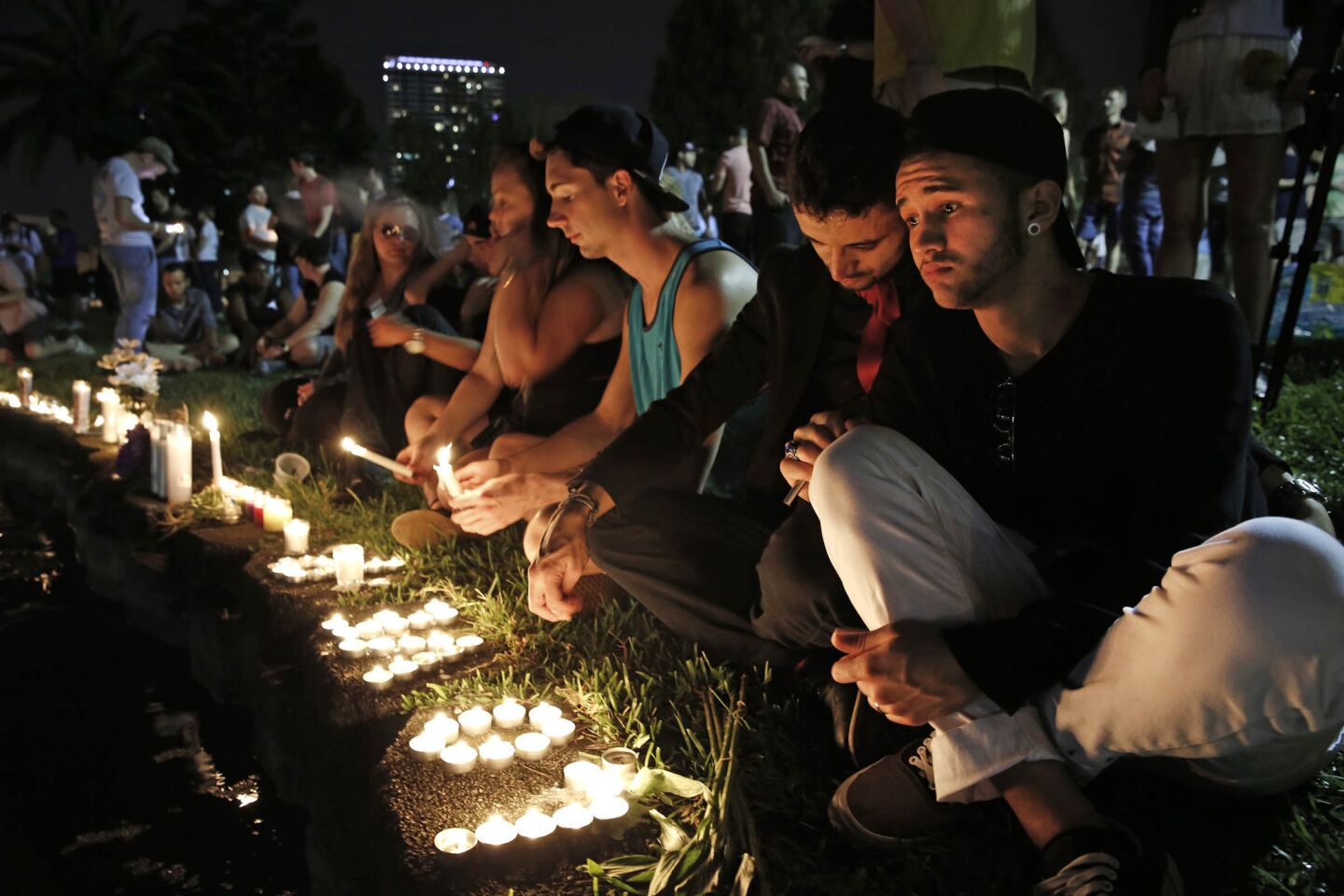 Johnpaul Vazquez, right, and his boyfriend Yazan Sale sit by Lake Eola, in downtown Orlando, thinking of those killed and injured.