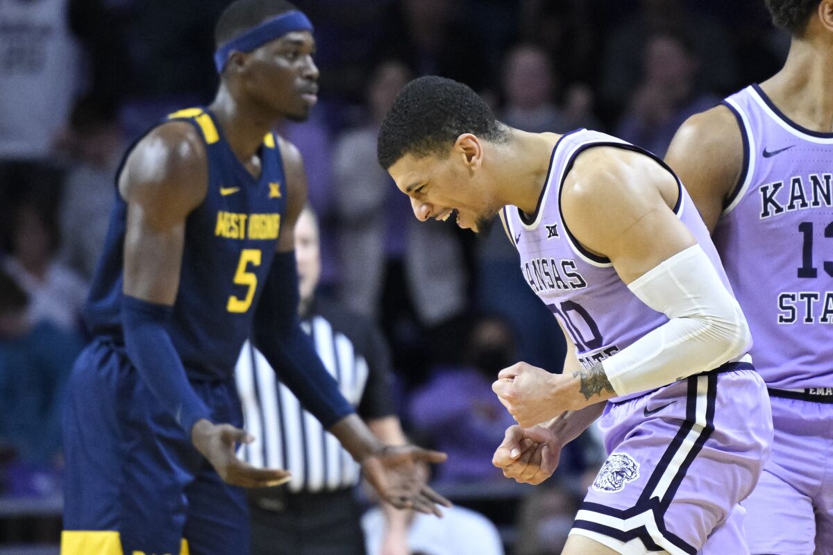 Kansas State guard Mike McGuirl, right, celebrates as time runs out in the team's NCAA college basketball game against West Virginia in Manhattan, Kan., Monday, Feb. 14, 2022. Kansas State won 78-73. (AP Photo/Reed Hoffmann)