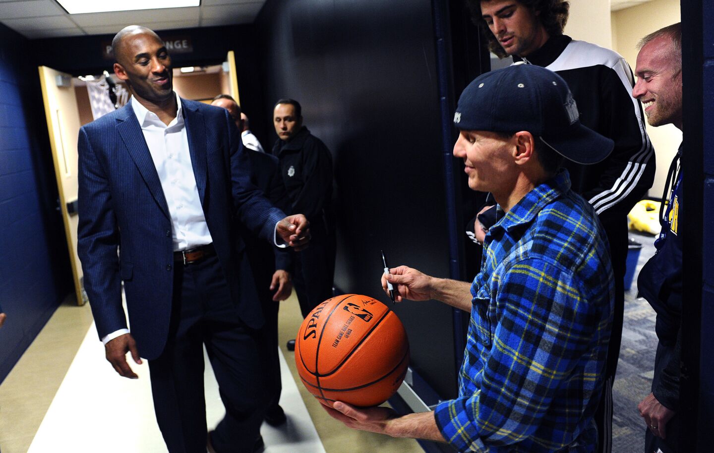Kobe Bryant prepares to sign an autograph for a fan at Pepsi Center after his last gamein Denver on March 2, 2016.