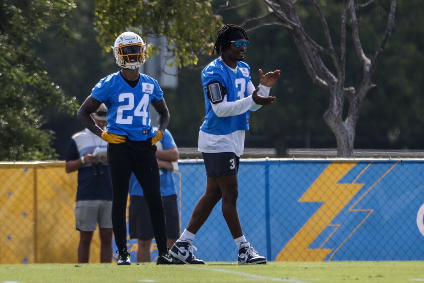Chargers safety Derwin James Jr. right, applauds alongside Nasir Adderley during training camp.