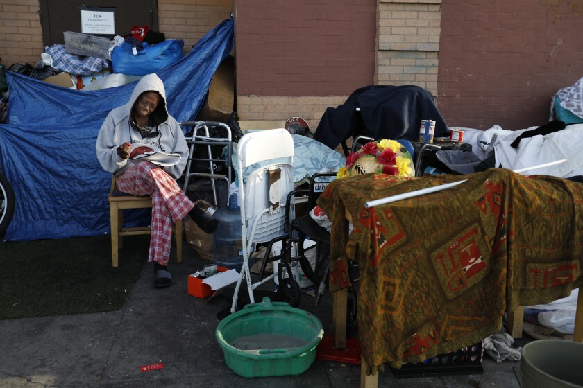 Sitting on the sidewalk, a woman who identified herself only as Ybette, 55, writes in her journal on 5th Street in the skid row neighborhood of Los Angeles.