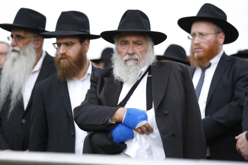 Rabbi Yisroel Goldstein of Chabad of Poway watches as Lori Gilbert-Kaye, 60, is laid to rest on April 28, 2019 in San Diego, California. Gilbert-Kaye was killed by a gunman at the synagogue. Goldstein lost a finger in the shooting.