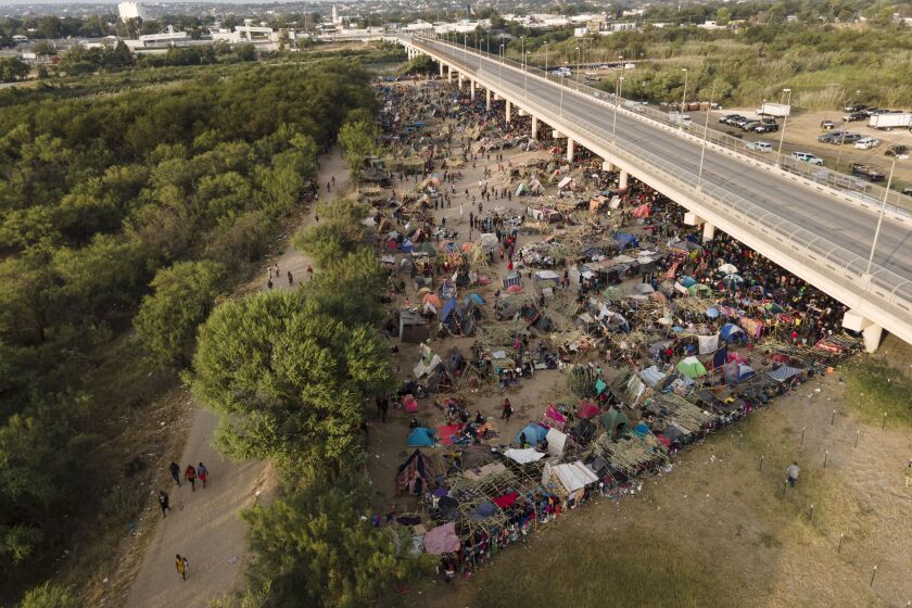 Migrants, many from Haiti, are seen at an encampment along the Del Rio International Bridge near the Rio Grande, Tuesday, Sept. 21, 2021, in Del Rio, Texas. The options remaining for thousands of Haitian migrants straddling the Mexico-Texas border are narrowing as the United States government ramps up to an expected six expulsion flights to Haiti and Mexico began busing some away from the border. (AP Photo/Julio Cortez)