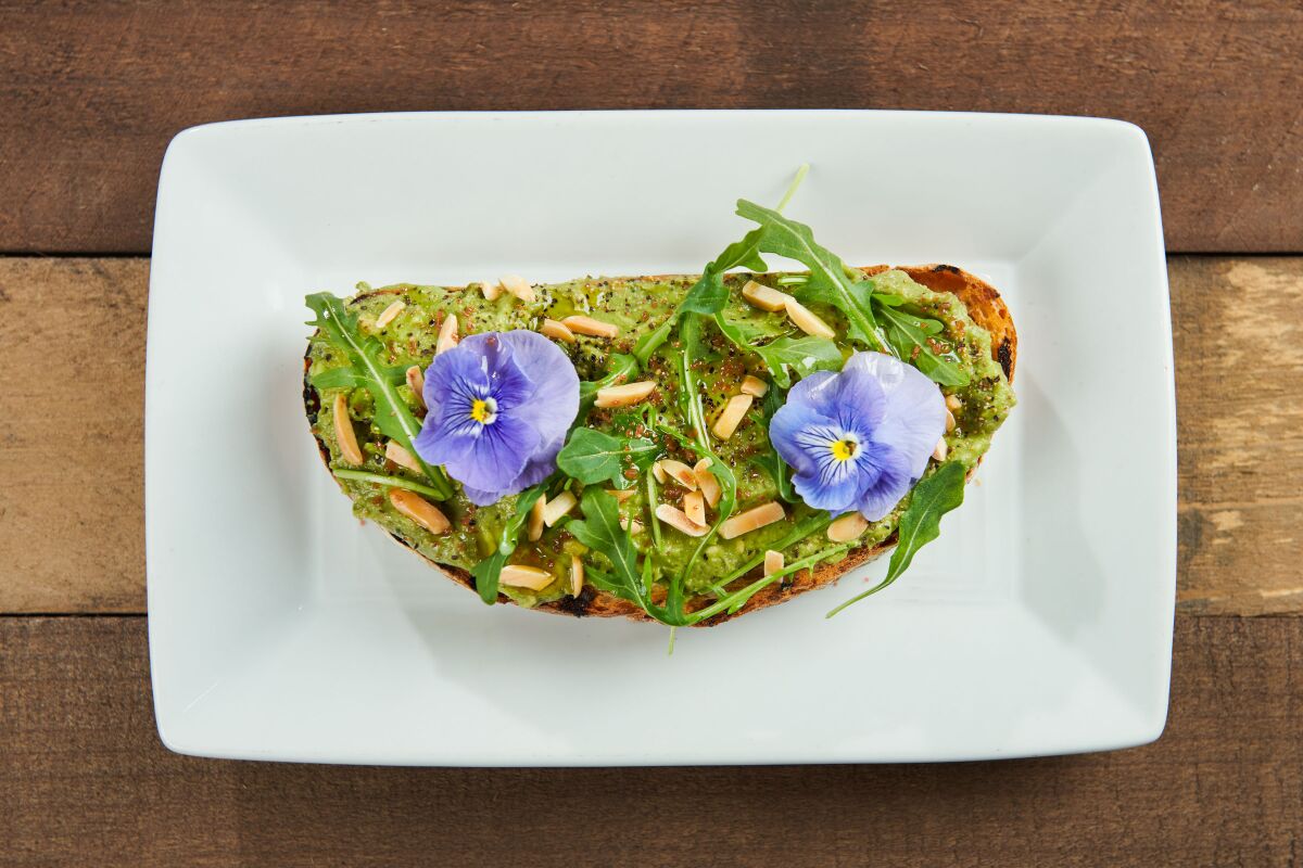 Edible flowers decorate this avocado toast dish at Toast Gastrobrunch in Carlsbad, which is participating this year in the city of Carlsbad's annual Petal to Plate events tied into the spring season at The Flower Fields.