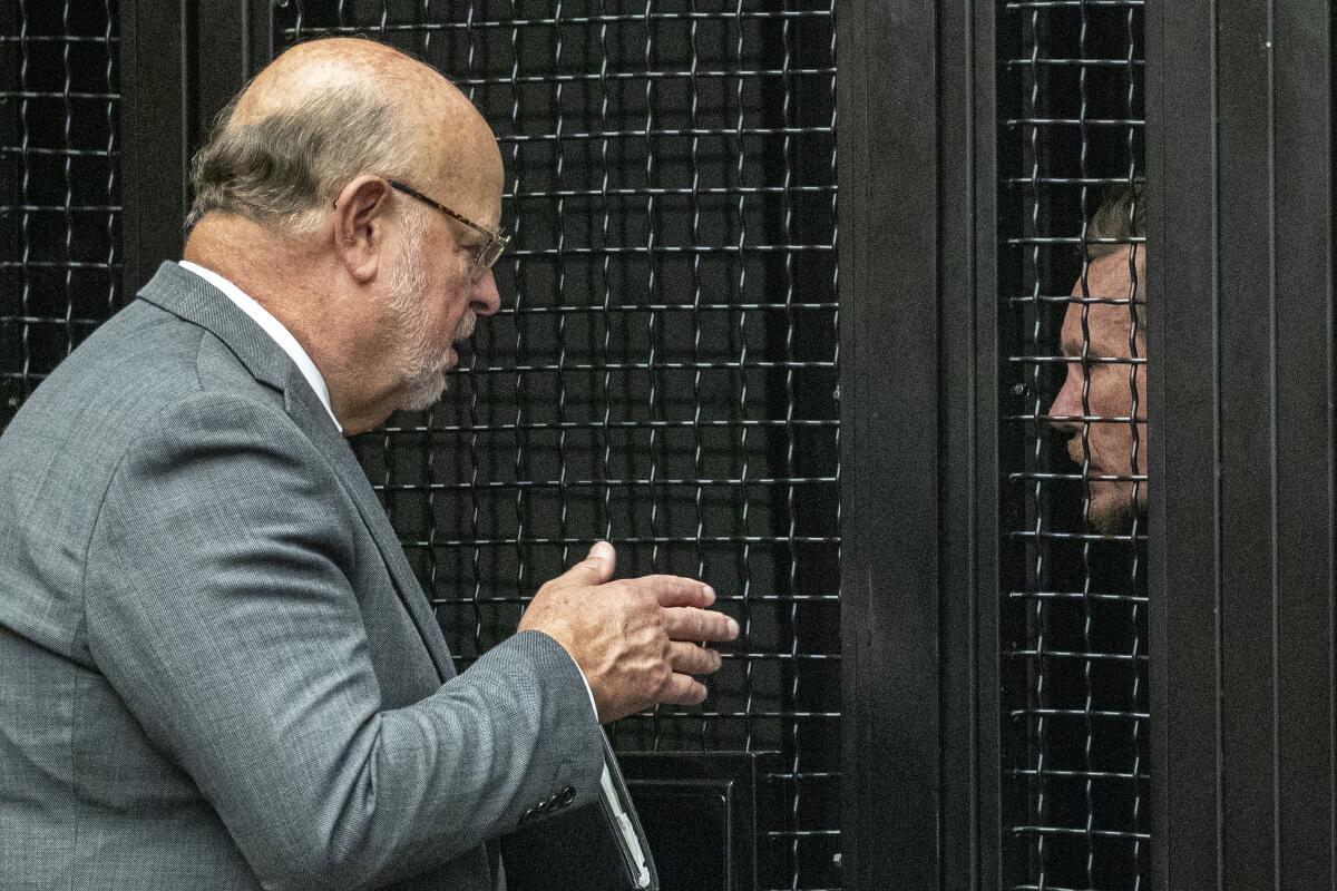 Defense attorney Robert Sanger, left, talks to Peter Chadwick at a hearing in Santa Ana, Calif.