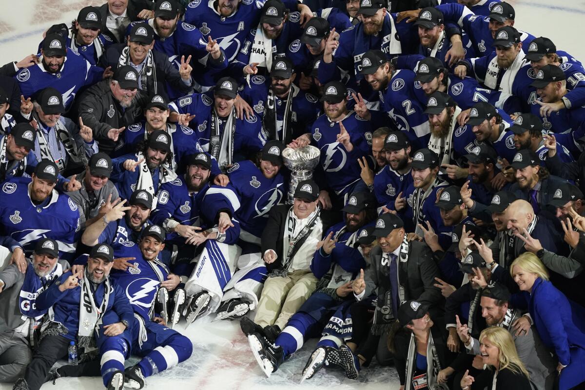 The Tampa Bay Lightning team poses with the Stanley Cup after Game 5 of the NHL hockey Stanley Cup finals against the Montreal Canadiens, Wednesday, July 7, 2021, in Tampa, Fla. (AP Photo/Gerry Broome)