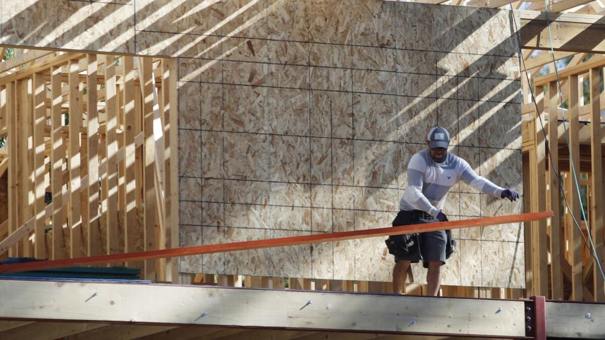 A worker toils on a new home in Denver. Experts say falling union membership is partly responsible for a decline in men's pay, after adjusting for inflation.