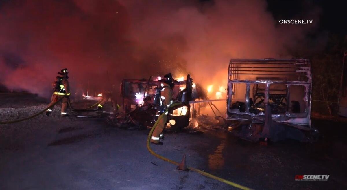 Chula Vista firefighters work to extinguish a blaze that destroyed three RVs Monday night at the San Diego Metro KOA Resort.