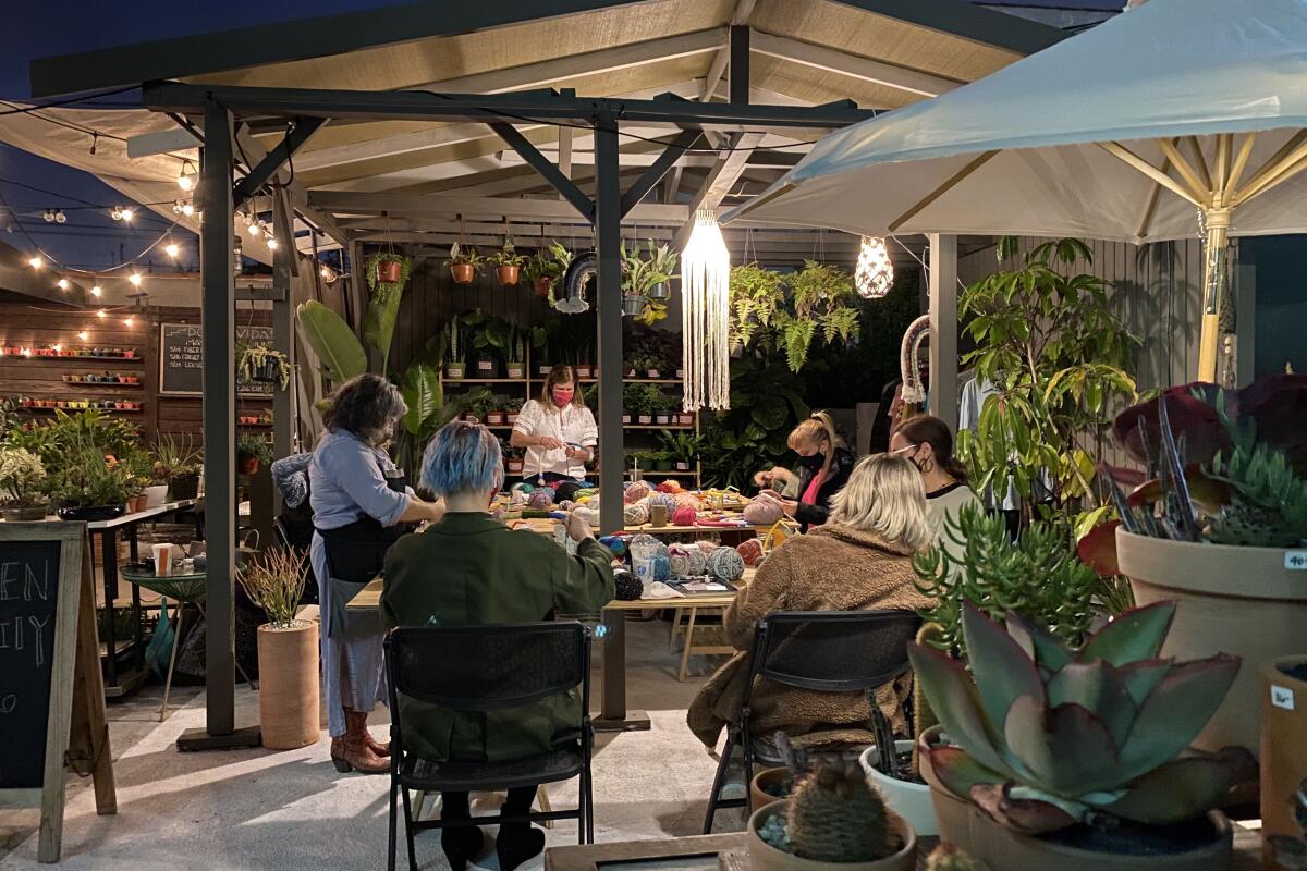 Women sit around an outdoor table at night, making things