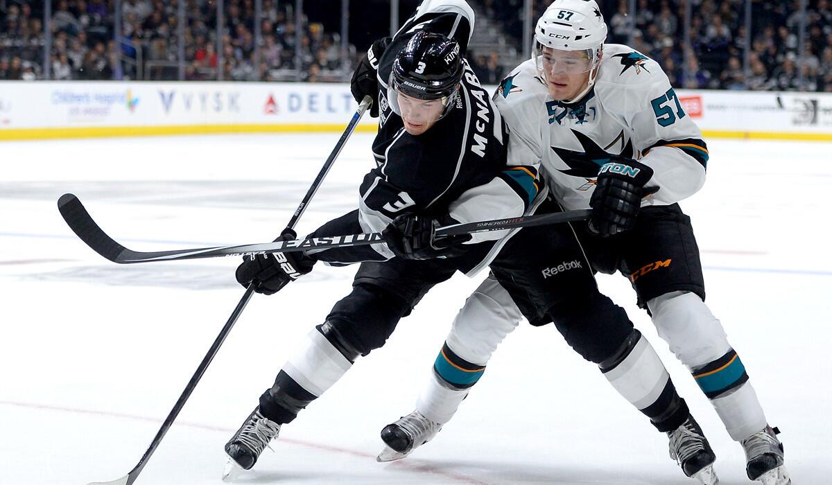 Kings defenseman Brayden McNabb battles Sharks center Tommy Wingels for the puck during the season opener on Tuesday at Staples Center.