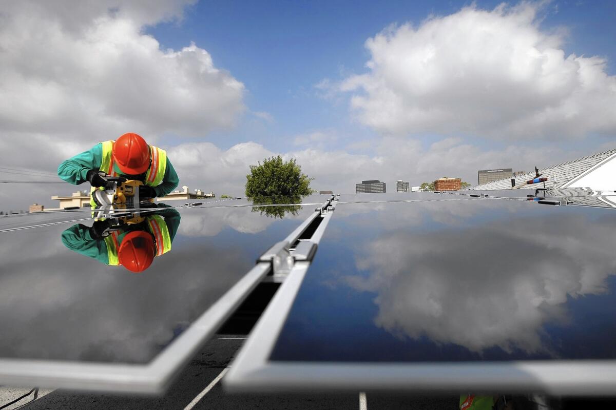 A SolarCity installer puts solar panels on a home in L.A. in 2009.