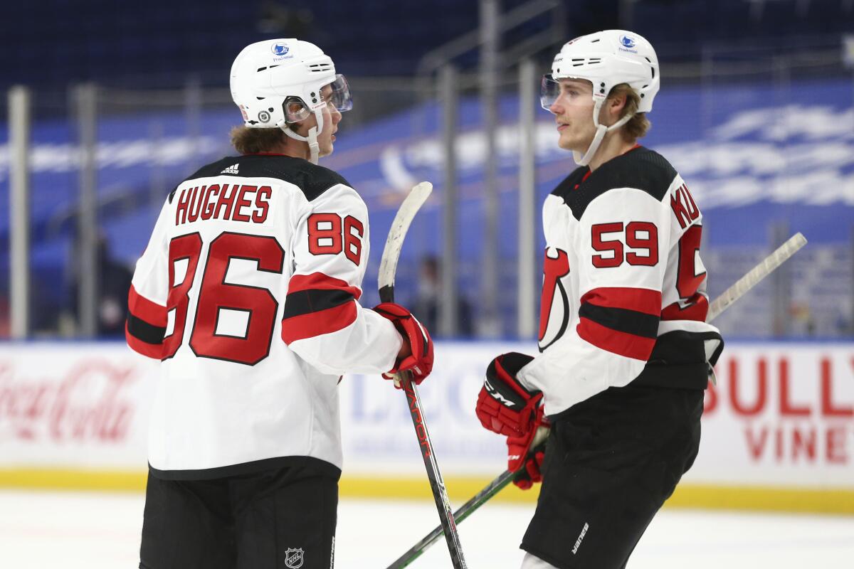 New Jersey Devils forward Jack Hughes (86) celebrates his goal with forward Janne Kuokkanen (59) during the first period of the team's NHL hockey game against the Buffalo Sabres, Thursday, April 8, 2021, in Buffalo, N.Y. (AP Photo/Jeffrey T. Barnes)