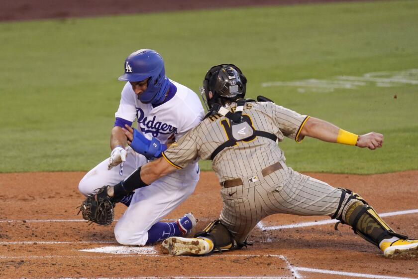 Los Angeles Dodgers' Chris Taylor, left, collides with San Diego Padres catcher Austin Hedges as he is tagged out while trying to score on a double by Kiké Hernández during the second inning of a baseball game Tuesday, Aug. 11, 2020, in Los Angeles. (AP Photo/Mark J. Terrill)