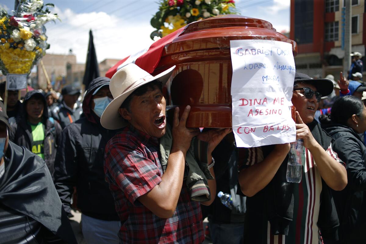 People carry a coffin with the name of the deceased and message against Peru's president. 