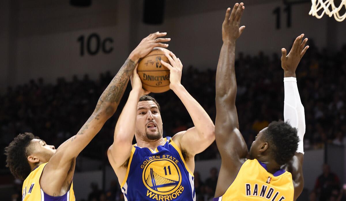 The Lakers' Brandon Ingram, left, and Julius Randle harass Golden State's Klay Thompson Wednesday in San Diego.