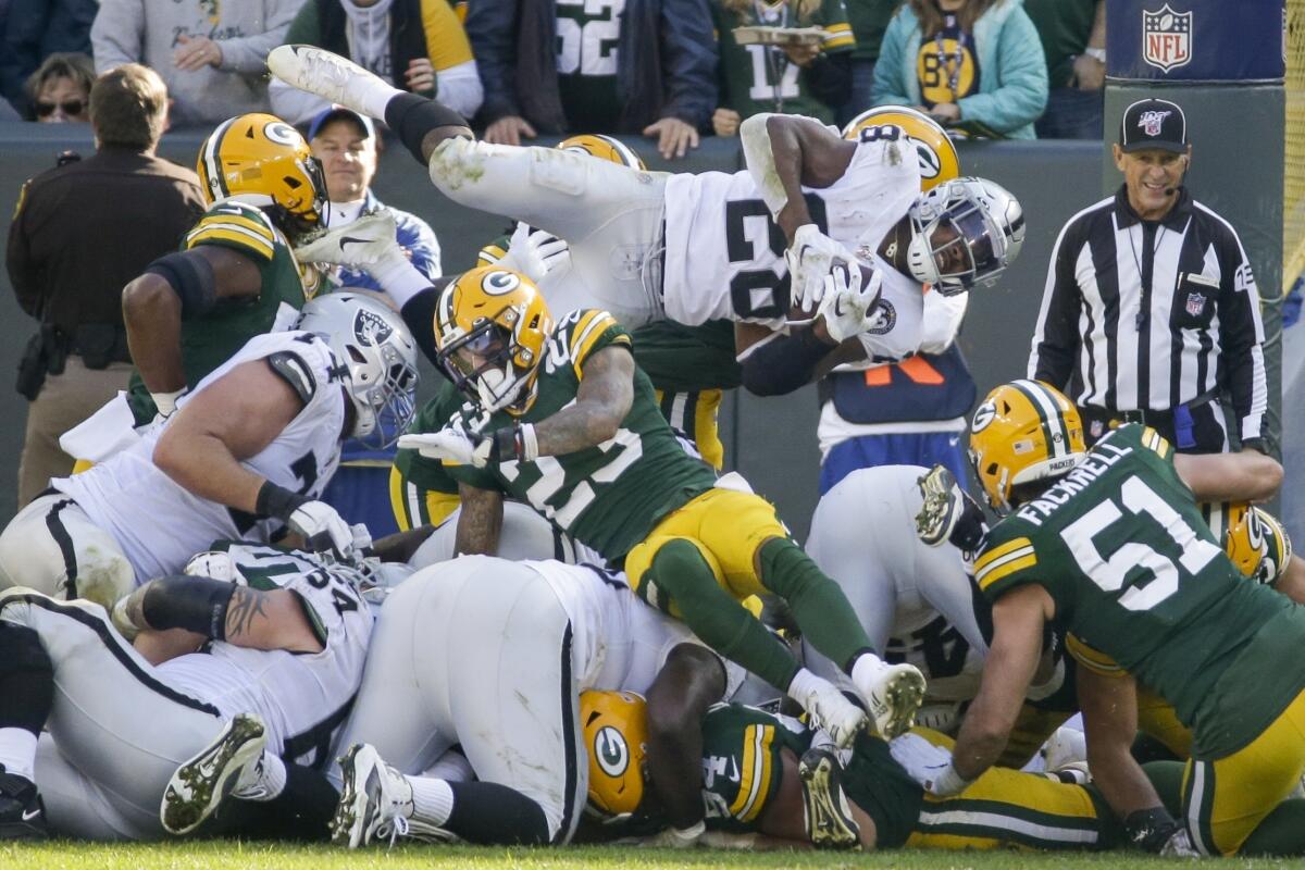 Raiders running back Josh Jacobs tries leaping his way to a first down, but the Packers eventually held him short of the mark.