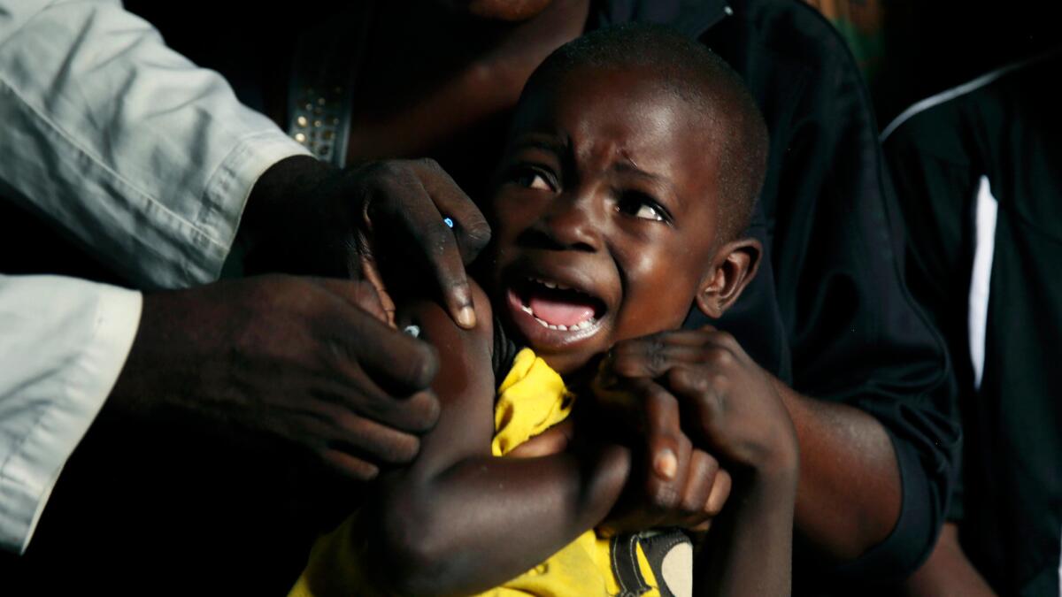 A boy reacts as he receives a yellow fever vaccine injection in the Kisenso district of Kinshasa.
