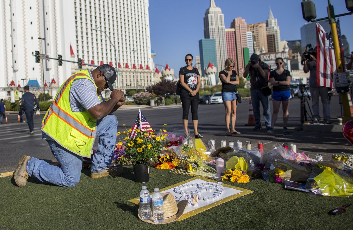 Contractor Robert Walker says a prayer after placing flowers and American flag at the scene of a memorial for the victims of the mass shooting on Las Vegas Boulevard near the crime scene.