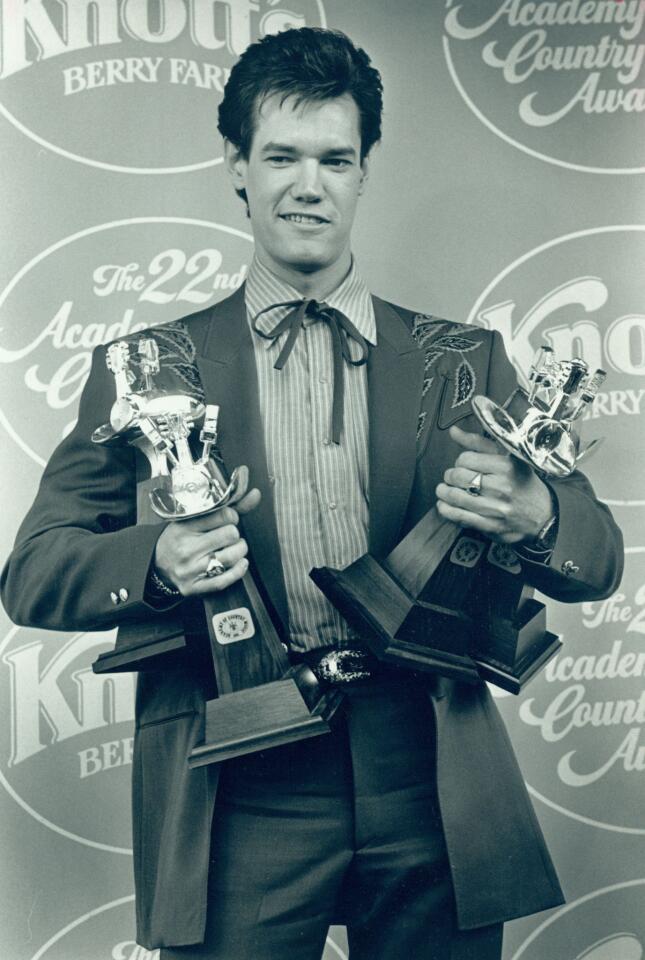 Randy Travis found success after tough beginnings. Travis was turned away by every major record label in Nashville (even Warner Bros., his eventual employer, rejected him twice), but his debut album, "Storms of Life," sold more than 4 million units. Travis' second Warner Bros. album, "Always and Forever," and a few hit songs including "Forever and Ever, Amen," catapulted him to the forefront of the country music scene. Here, he's at the 22nd Country Music Awards. He won for top male vocalist, album of the year, song of the year and single of the year.