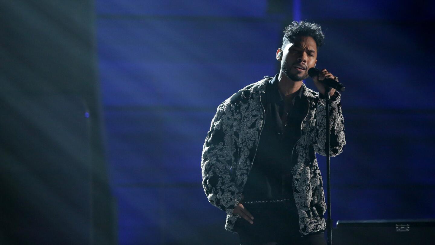 Miguel performs the song "Off the Wall" onstage.
