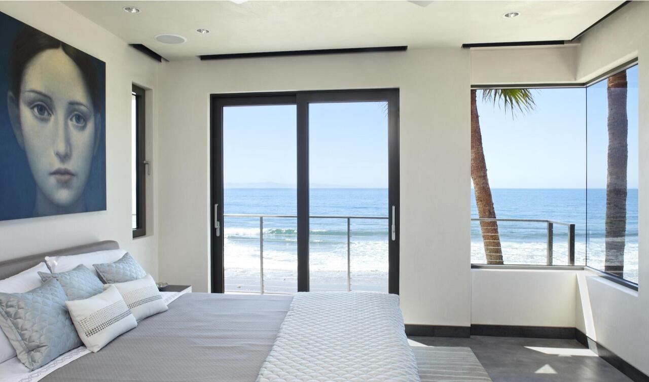 French doors and large windows show the beach and ocean.