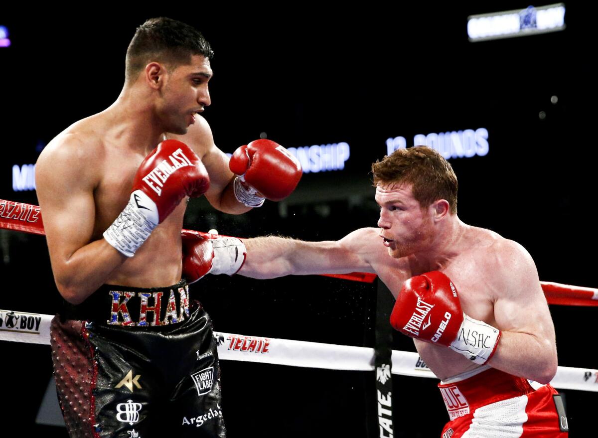 Canelo Alvarez lands a right to the body of Amir Khan during their WBC middleweight title fight Saturday at T-Mobile Arena.