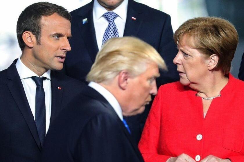 epa05989737 French President Emmanuel Macron (L) talks with German Chancellor Angela Merkel (R) as US President Donald J. Trump (C) walks by, during a line up for the group photo at the NATO summit in Brussels, Belgium, 25 May 2017. NATO countries' heads of states and governments gather in Brussels for a one-day meeting. EPA/ARMANDO BABANI ** Usable by LA, CT and MoD ONLY ** ** Usable by LA, CT and MoD ONLY **