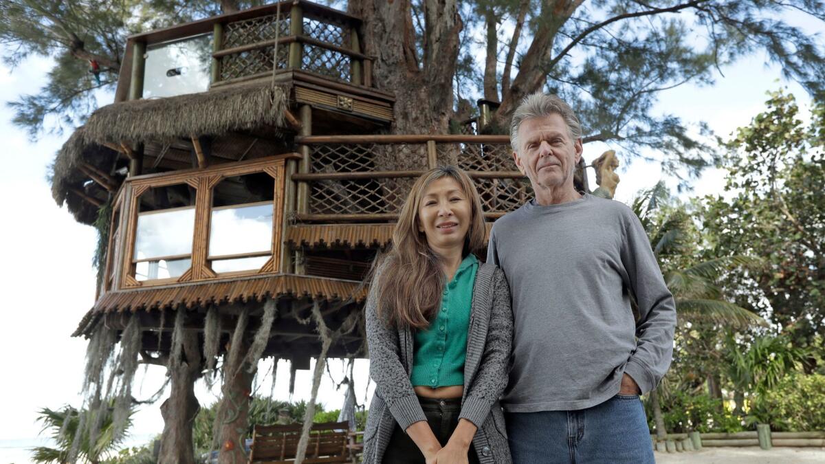 Lynn Tran and her husband, Richard Hazen, pose near their Australian pine treehouse Jan. 4 in Holmes Beach, Fla. The couple is hoping the U.S. Supreme Court will hear their case after city and state officials ordered the treehouse removed.