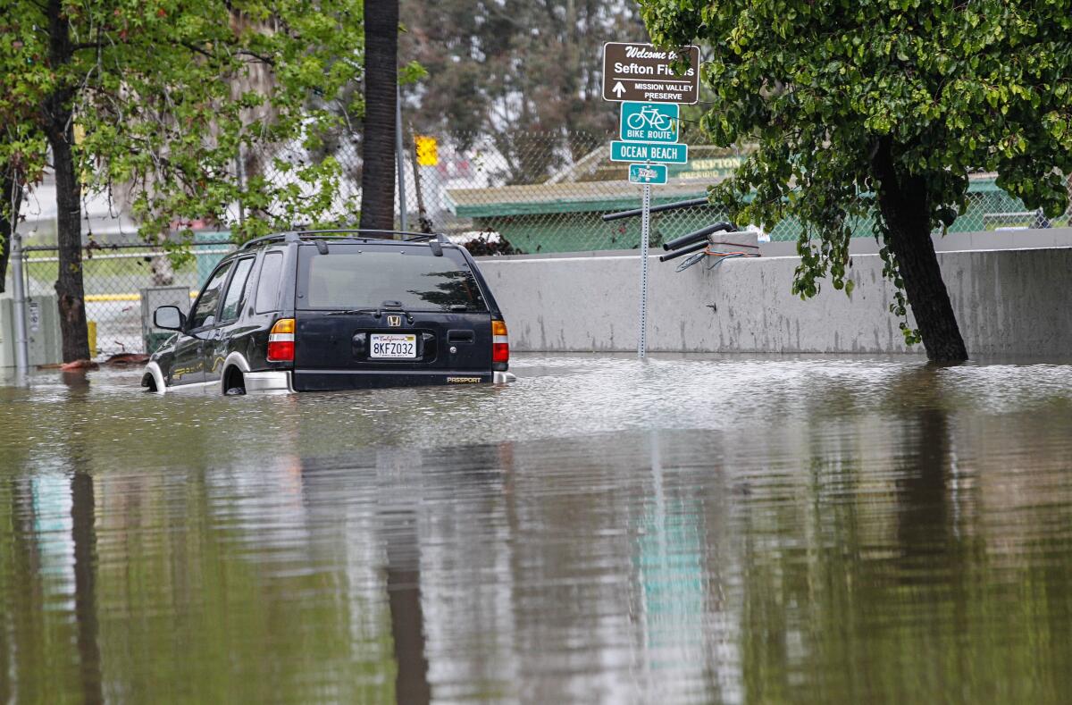 A car sits in area flooded by heavy rain and the rising San Diego River in Mission Valley last April.