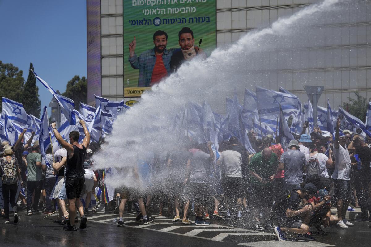 Israeli police using a water cannon to disperse demonstrators