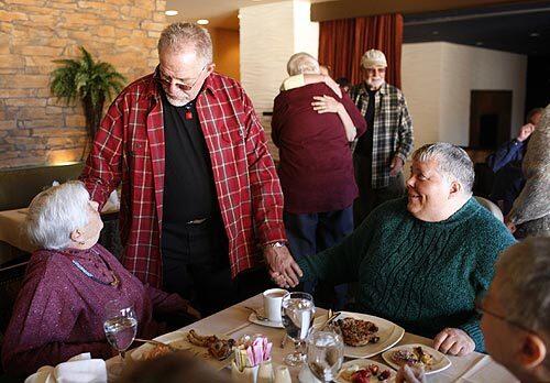 Jack Norris, center, greets fellow residents Gloria Donadello, left, and Mary Ellen Babcock during brunch at RainbowVision.