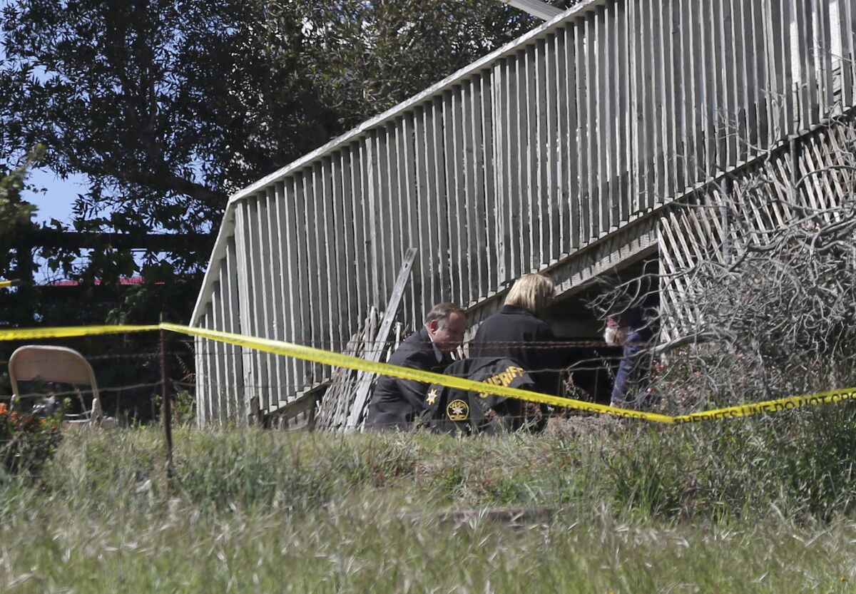 San Luis Obispo Sheriff's Office personnel dig under the deck of the home of Ruben Flores, March 16, 2021, in Arroyo Grande.