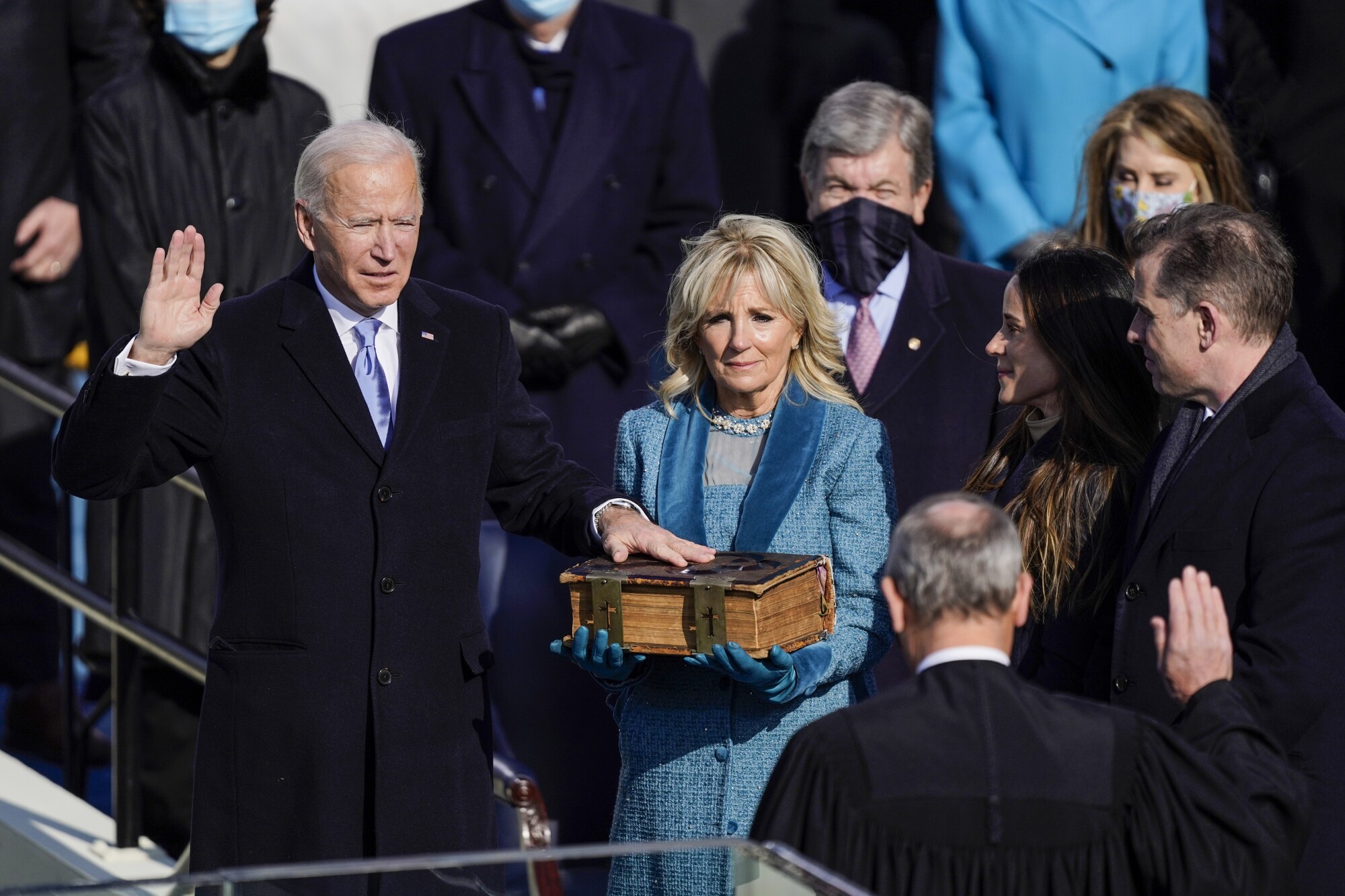 President Biden raises his right hand as his left rests on a Bible held by his wife, Jill