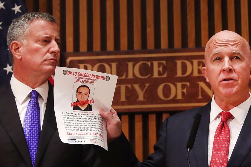 New York City Police Commissioner James O'Neill holds a picture of Ahmad Khan Rahami during a news conference with Mayor Bill de Blasio.