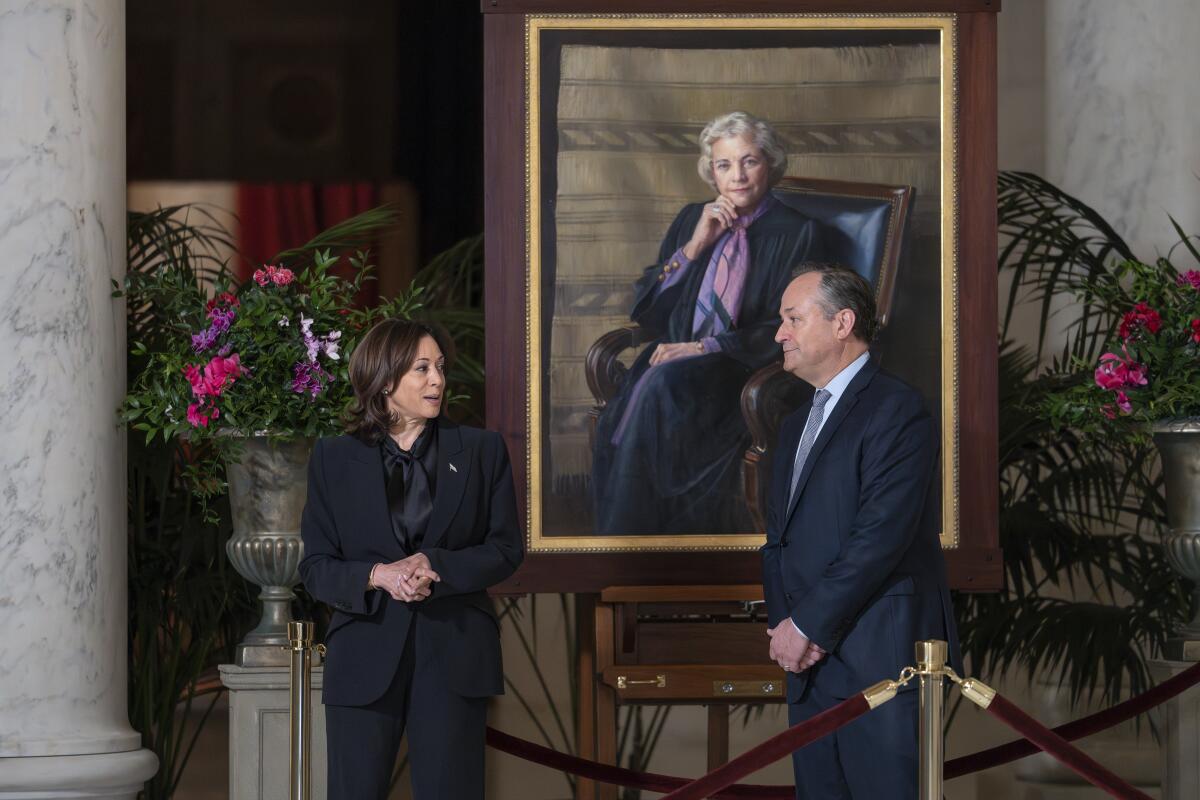 Vice President Kamala Harris and Doug Emhoff standing near a portrait of retired Supreme Court Justice Sandra Day O'Connor
