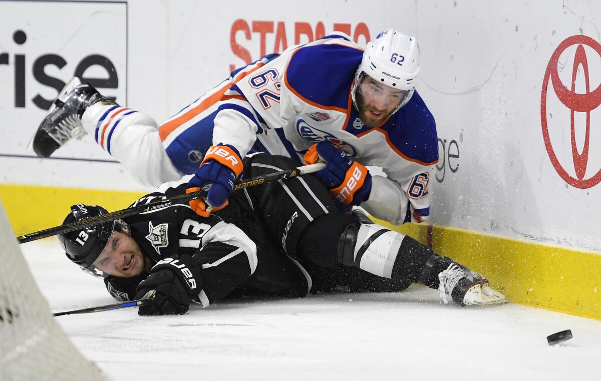 Kings left wing Kyle Clifford, below, and Oilers defenseman Eric Gryba fall as they compete for the puck during the second period on Nov. 17.