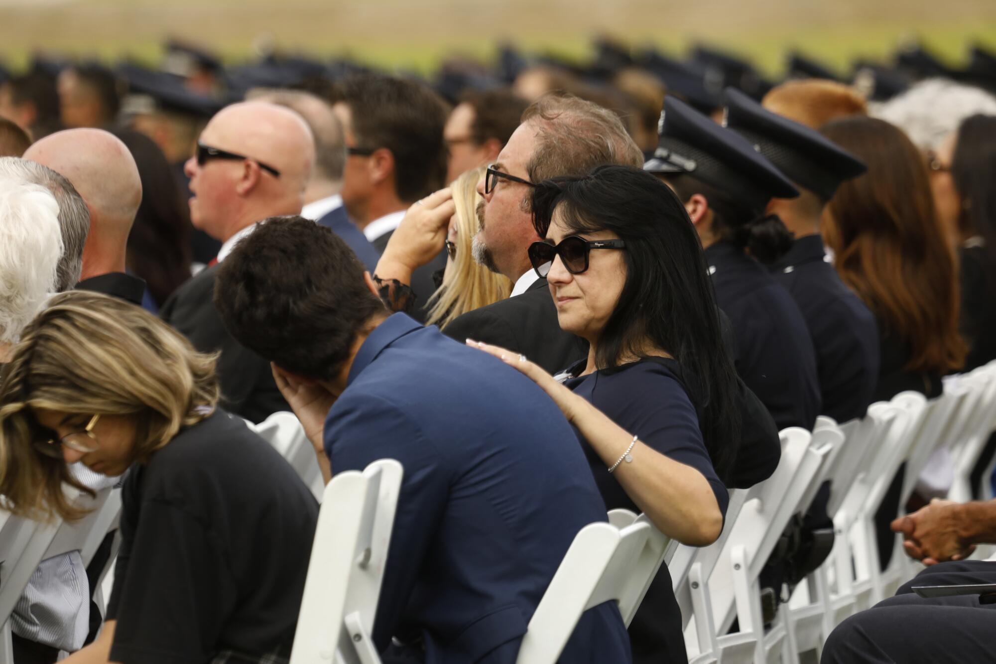 Family and friends comfort one another during the memorial