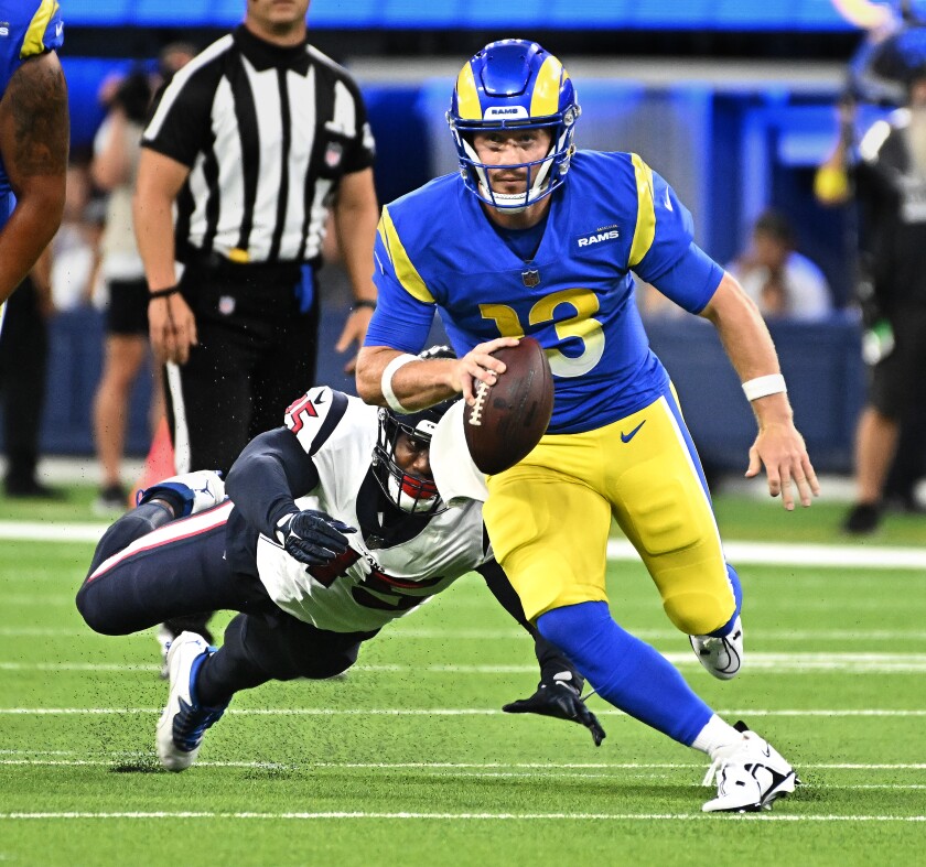 Rams quarterback John Wolford eludes Texans defensive lineman Ogbonnia Okoronkwo to pick up a first down Friday.