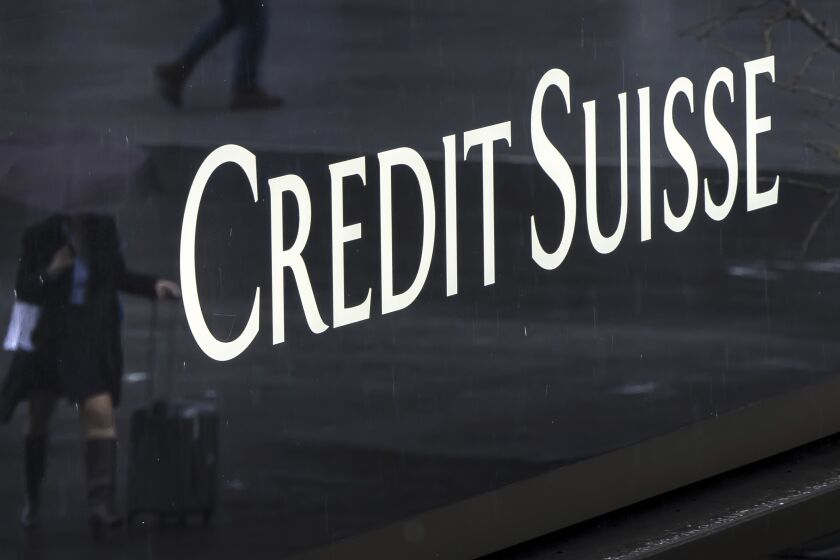 A woman walks past a logo of the Swiss bank Credit Suisse in Zurich, Switzerland, Friday, March 24, 2023. (Michael Buholzer/Keystone via AP)
