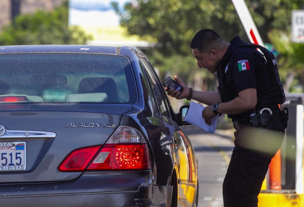 El oficial de policía de Tijuana, Alonzo Gastélum Bojorquez, escanea los documentos del pase de Fast Lane que los profesionales médicos les dan a los pacientes.