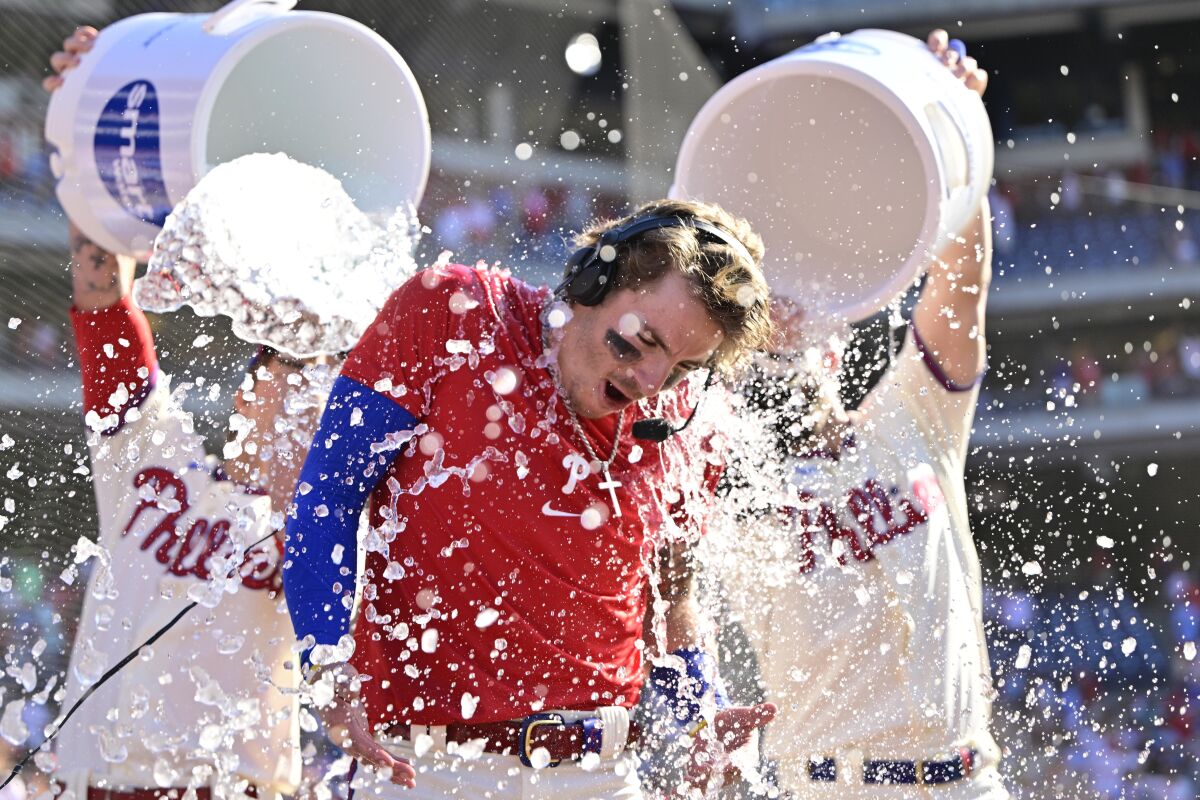 Philadelphia Phillies' Bryson Stott is doused by teammates after hitting a walkoff three-run home run during the ninth inning of a baseball game off Los Angeles Angels' Jimmy Herget, Sunday, June 5, 2022, in Philadelphia. (AP Photo/Derik Hamilton)