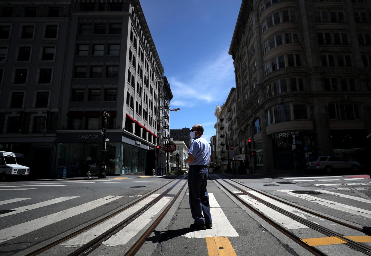 Un cartero del Servicio Postal de EE.UU en medio de la calle Powell, en San Francisco. San Francisco, San Mateo y Marín planean aliviar gradualmente sus restricciones de distanciamiento social a partir del lunes.