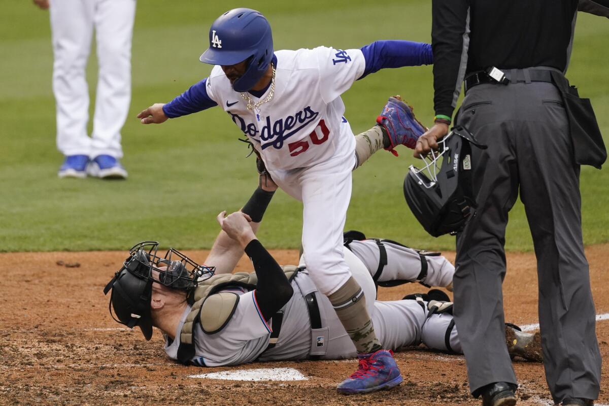 Miami Marlins catcher Chad Wallach, bottom, tags out Dodgers basrunner Mookie Betts at home.