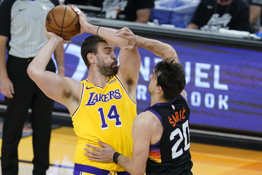 Los Angeles Lakers center Marc Gasol (14) gets fouled by Phoenix Suns forward Dario Saric (20) during the first half of Game 2 of their NBA basketball first-round playoff series Tuesday, May 25, 2021, in Phoenix. (AP Photo/Ross D. Franklin)